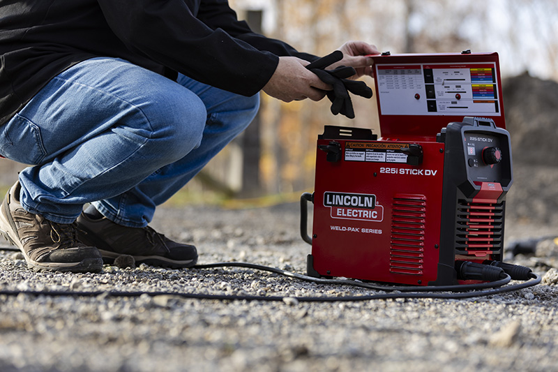 Worker prepares the 225i DV STICK WELDER for use